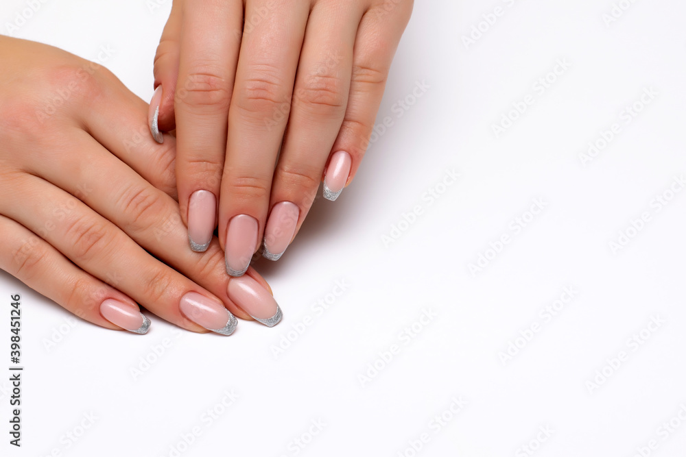 French silver manicure on long nails on a white background close-up. Bolero nail shape.