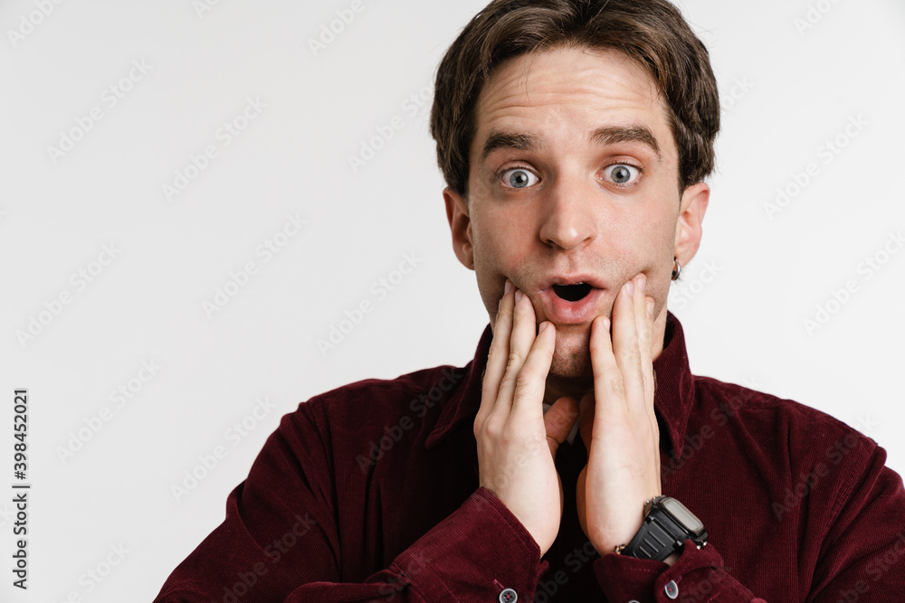Handsome astonished young man expressing surprise on camera Handsome astonished young man expressing surprise on camera