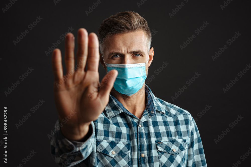Man wearing face mask and showing stop gesture Man wearing face mask and showing stop gesture