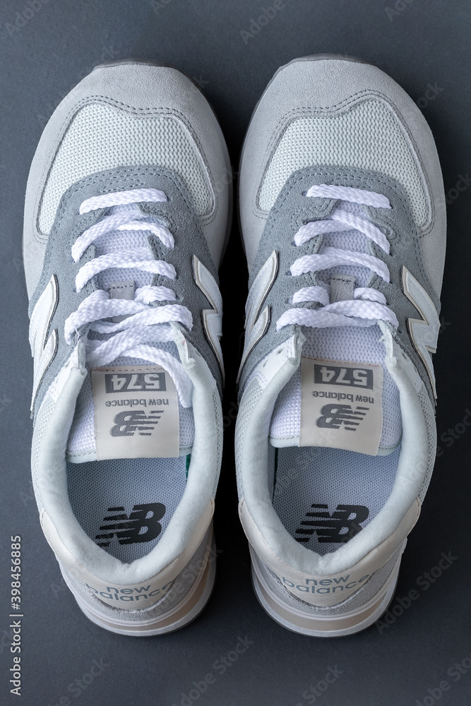 New Balance 574 light gray sneakers on gray background. Suede and