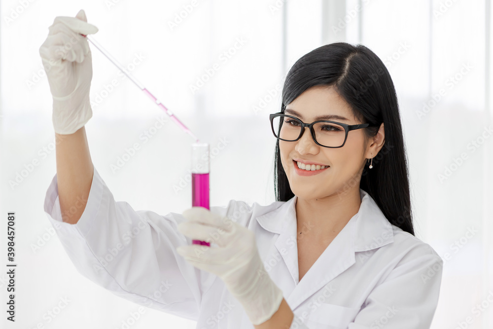 Young Asian scientist woman holding and looking at the chemical flasks in the laboratory
Young Asian scientist woman holding and looking at the chemical flasks in the laboratory