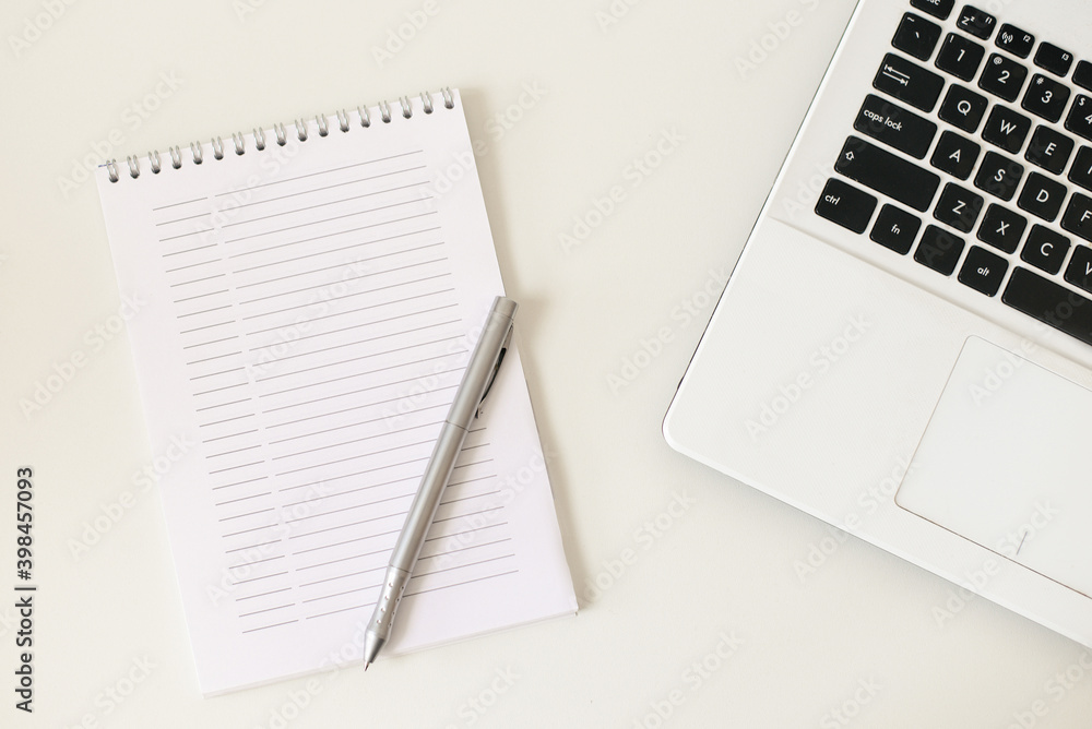 Notebook, pen and laptop on a white background. The daily is on the table. Workplace. Notebook, pen and laptop on a white background. The daily is on the table. Workplace.