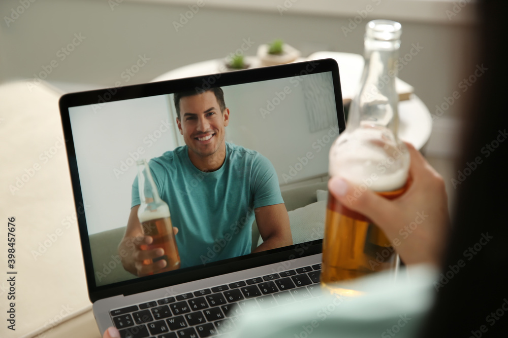 Friends drinking beer while communicating through online video conference at home. Social distancing during coronavirus pandemic Friends drinking beer while communicating through online video conference at home. Social distancing during coronavirus pandemic