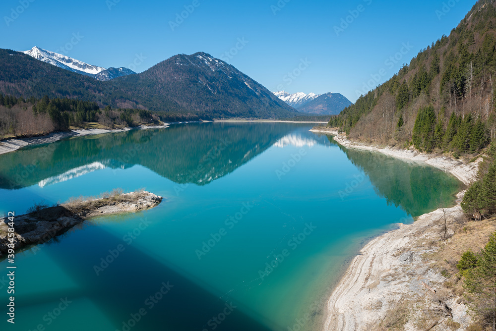 turquoise lake Sylvenstein at early springtime with water reflection, bavarian landscape