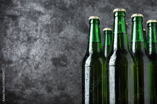 Bottles of beer on grey background, closeup. Space for text