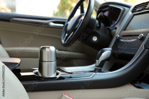 Silver thermos in holder inside of car photo