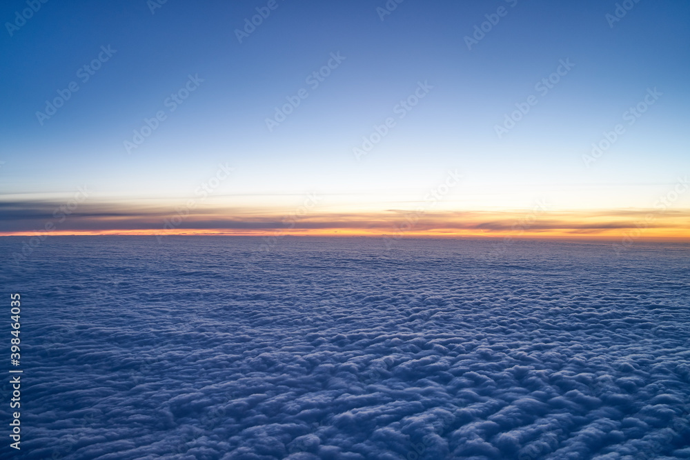 Evening sky just after sunset with a low layer of clouds as seen from an airplane