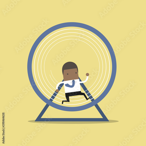 African businessman running in a hamster wheel.