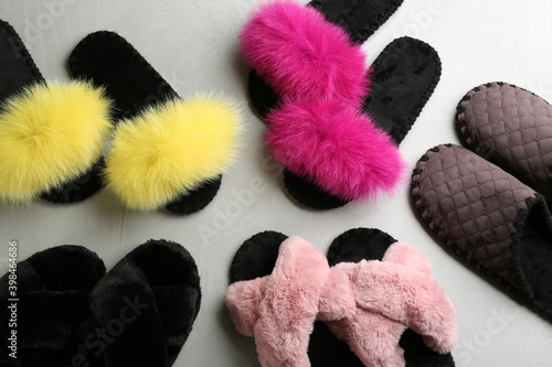 Many different soft slippers on light grey background, flat lay