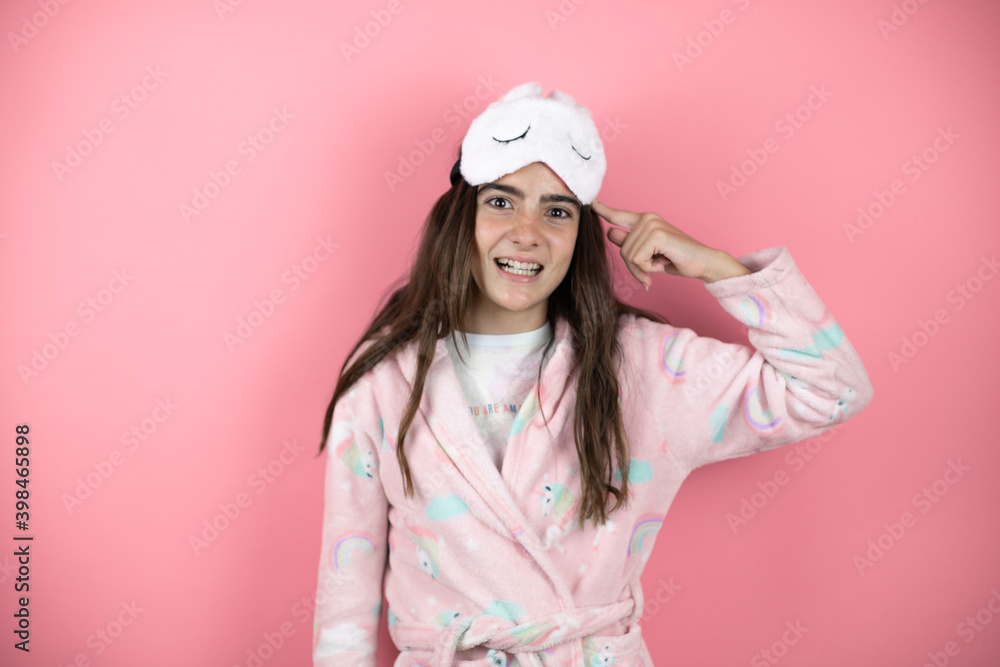 Pretty girl wearing pajamas and sleep mask over pink background having an idea Pretty girl wearing pajamas and sleep mask over pink background having an idea