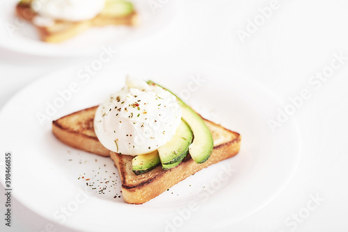 Toast with poached eggs and avocado. Healthy breakfast and food. Cozy morning. Nutrition for pregnant. Diet for women. Breakfast in hotel room or bed. Scrambled eggs sandwich.