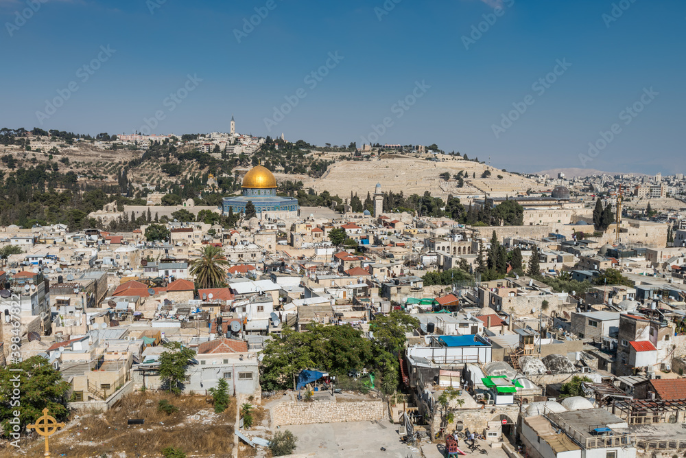 Aerial view of rooftops of the old city of Islamic quarter with blue sky of Jerusalem, with Golden Dome of Rock and Mount of Olives,  View from the Lutheran Church of the Redeemer.