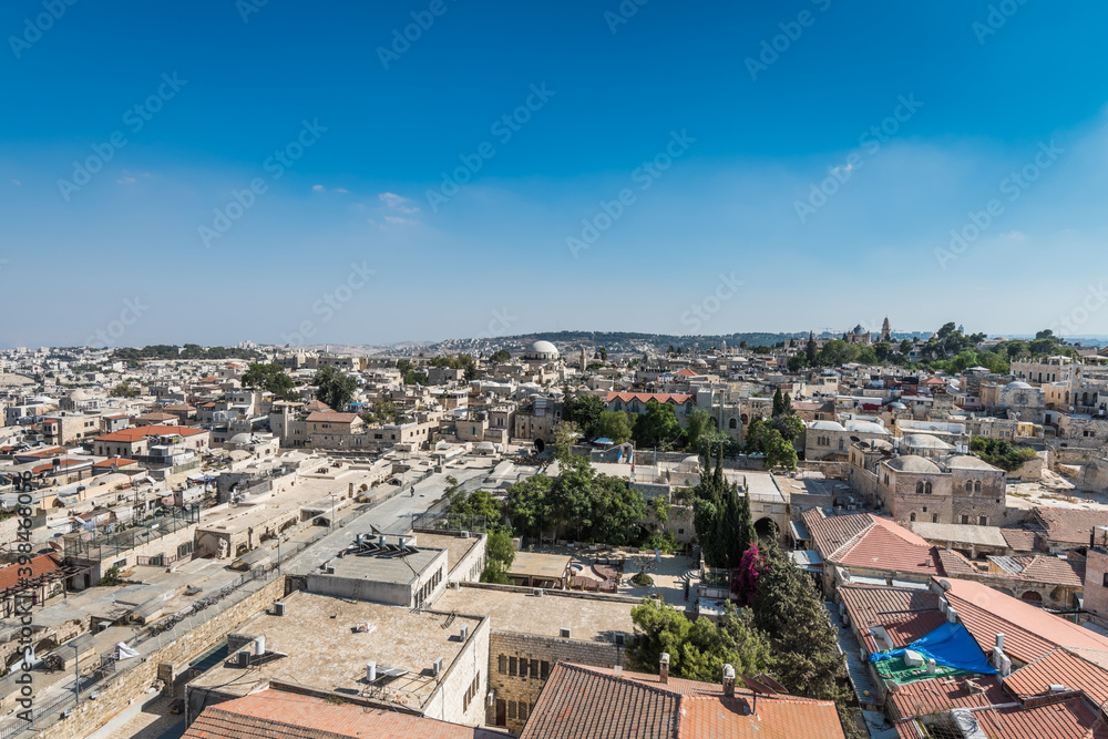 Aerial view of rooftops of traditional buildings and Hurva Synagogue in the old city with blue sky of Jerusalem. View from the Lutheran Church of the Redeemer.