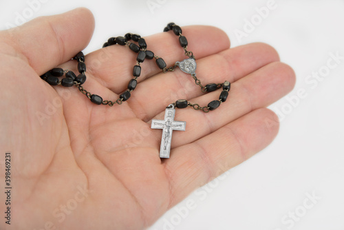 Christian necklace in a hand on a white