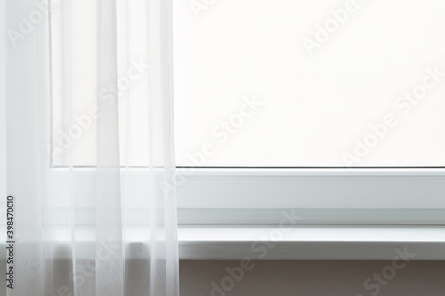 Opened day curtains at window in room. Empty windowsill. Free place for text on white glass. Front view. Closeup.