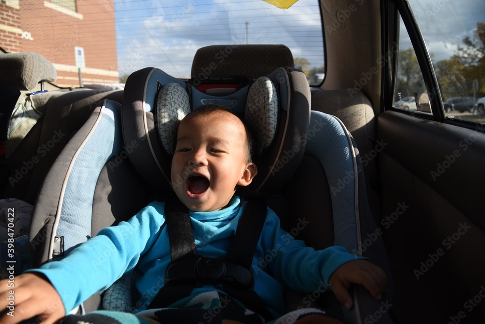 A cute asian toddler boy on the car seat in car A cute asian toddler boy on the car seat in car