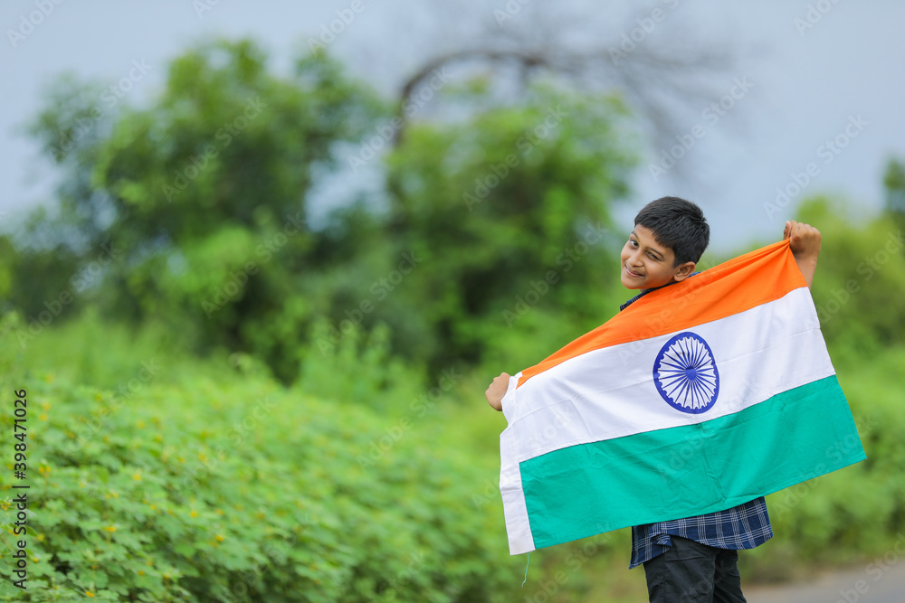 Cute little boy waving Indian National Tricolor Flag over nature background Cute little boy waving Indian National Tricolor Flag over nature background
