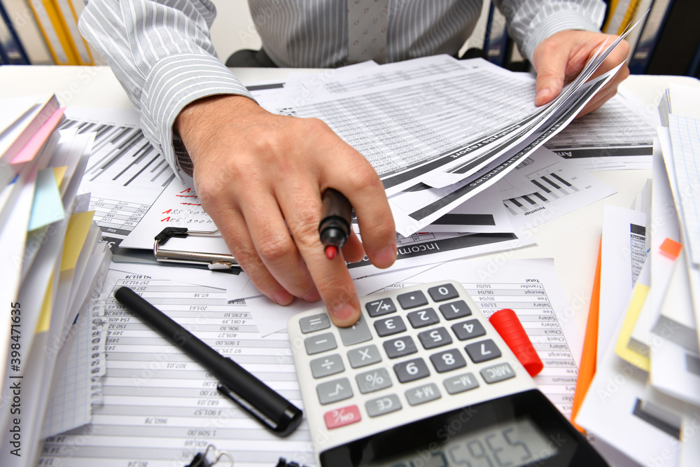 business concept - businessman working with reports in office, table and workspace close view, analyzing financial data, writes and counts business concept - businessman working with reports in office, table and workspace close view, analyzing financial data, writes and counts