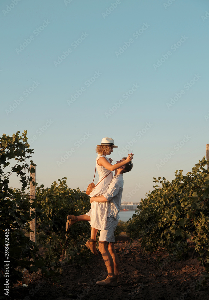 Couple with glasses drinks wine in vineyaed Couple with glasses drinks wine in vineyaed