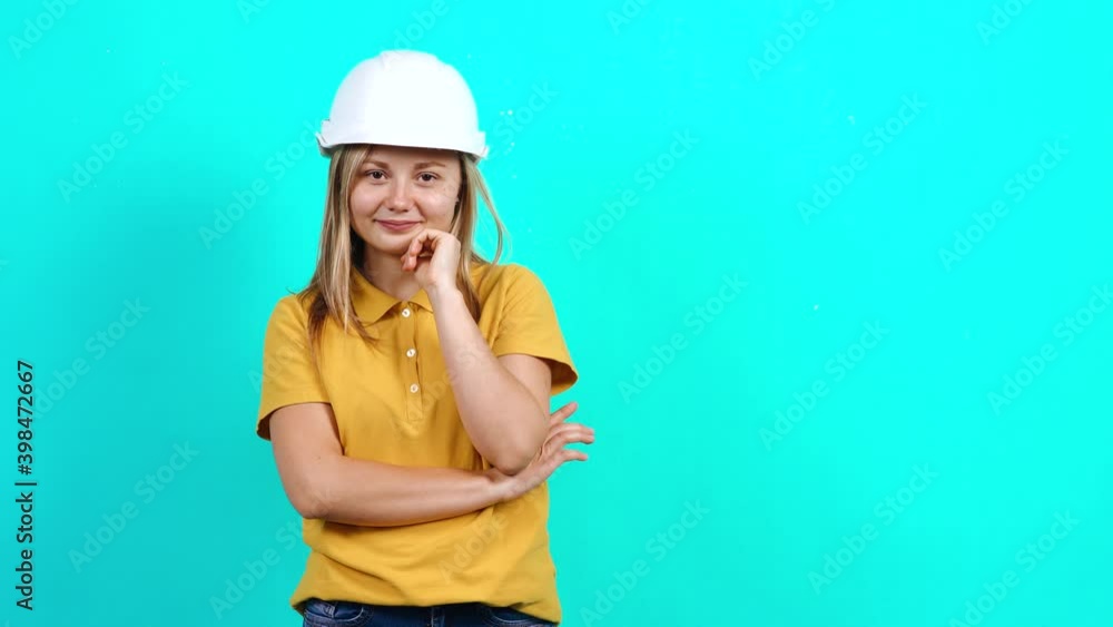 The happy young engineer smiles at the camera. Beautiful Caucasian woman in yellow t-shirt and long blond hair standing on blue background. A fat teenager. Advertising concept. The happy young engineer smiles at the camera. Beautiful Caucasian woman in yellow t-shirt and long blond hair standing on blue background. A fat teenager. Advertising concept.