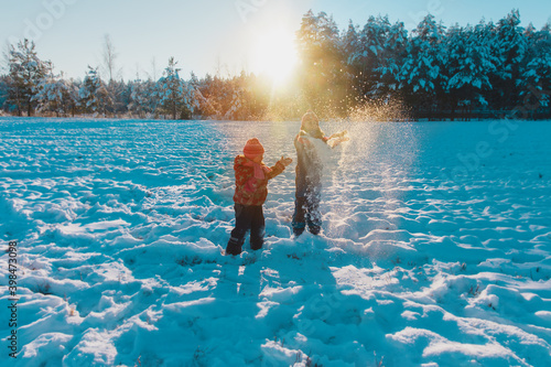 Happy kids play with snow in winter nature