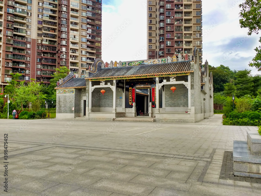 Small temple and tall residential buildings.  Guangzhou. Guangdong. China. Asia
