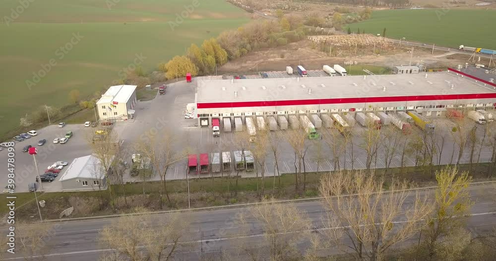 Aerial view of goods warehouse. Logistics center in industrial city zone from above. Aerial view of trucks loading at logistic center Aerial view of goods warehouse. Logistics center in industrial city zone from above. Aerial view of trucks loading at logistic center