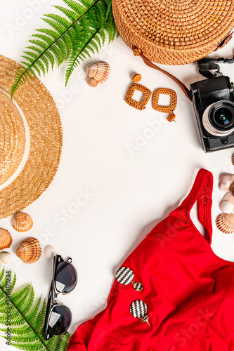 A set of accessories and a women's swimsuit are on a white table. Background for travel and vacation, space for text.