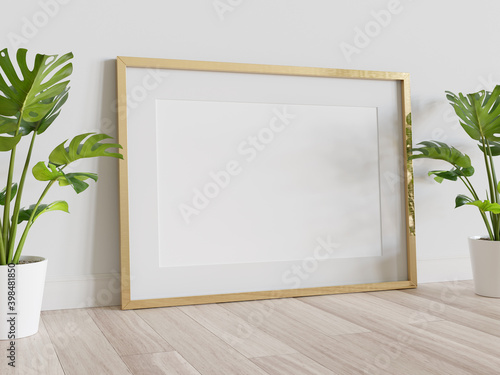 Fototapeta Naklejka Na Ścianę i Meble -  Golden frame leaning on floor in interior mockup. Template of a picture framed on a wall 3D rendering