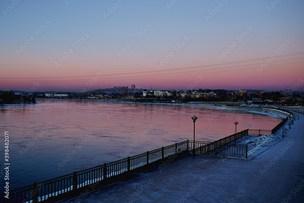 Embankment of the Angara river at sunset. Winter cityscape
