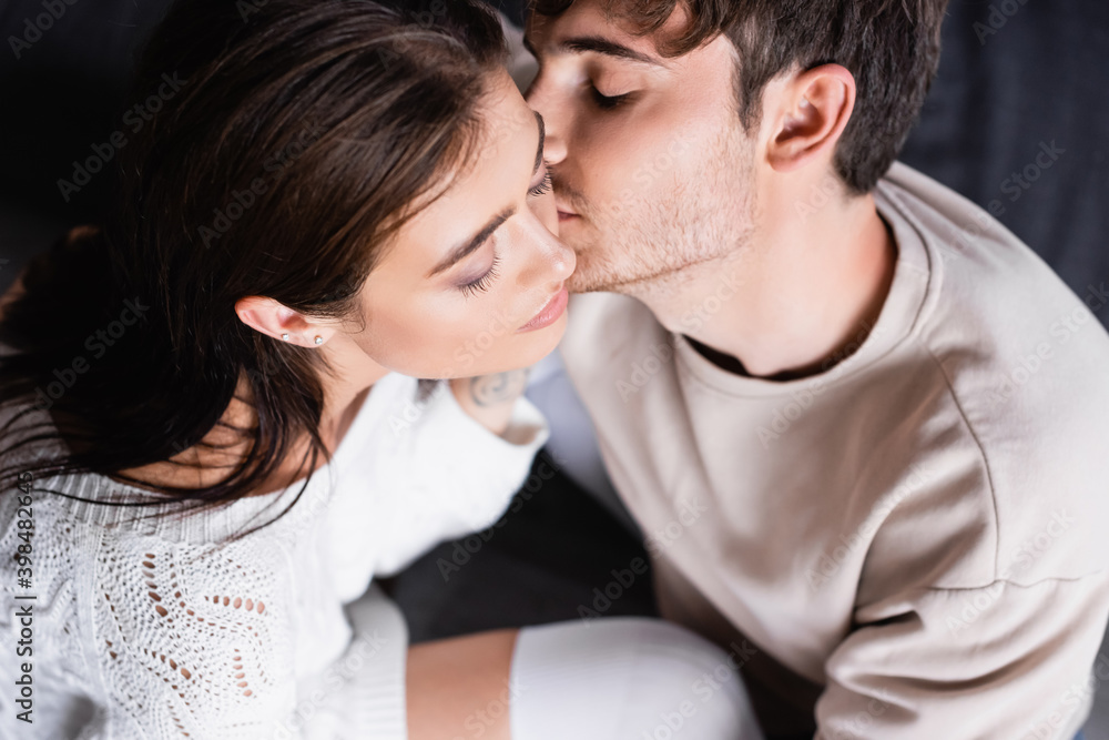 Overhead view of man kissing girlfriend at home Overhead view of man kissing girlfriend at home