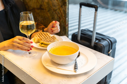 Woman having a drink with soup and sandwich in an airport restaurant