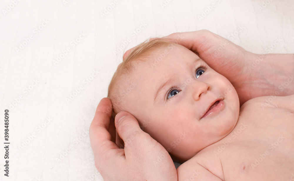 Baby and parent concept. Father's hands hugging face of five month cute caucasian baby, isolated. Close-up. Copy space for text. Baby and parent concept. Father's hands hugging face of five month cute caucasian baby, isolated. Close-up. Copy space for text.