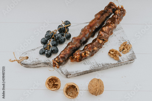 Fotografie bunch of grapes and churchkhela with walnuts on a light background