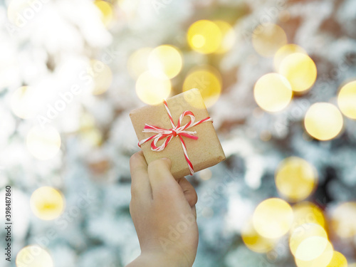 hand holding gift box over blurry snow winter background for Christmas holoday. photo