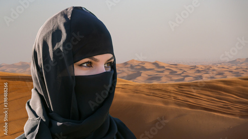 Portrait of beautiful islamic woman in hijab on desert background.