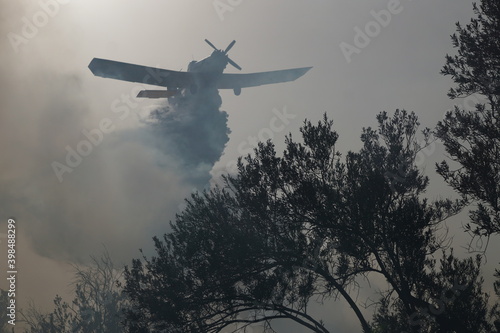 2017. LESBOS, GREECE. The firebrigade in Lesbos is trying to extinguish a fire with the help of volunteers and airplanes. photo