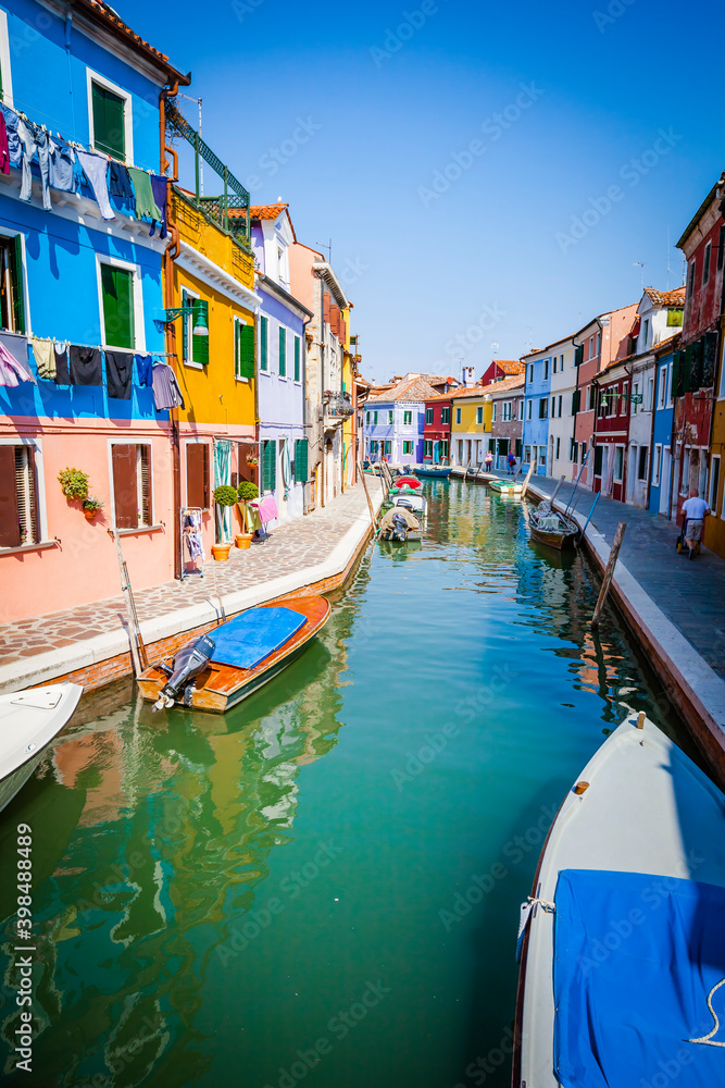 Boats in the channels of Burano, colourful island in the bay of Venice, Italy