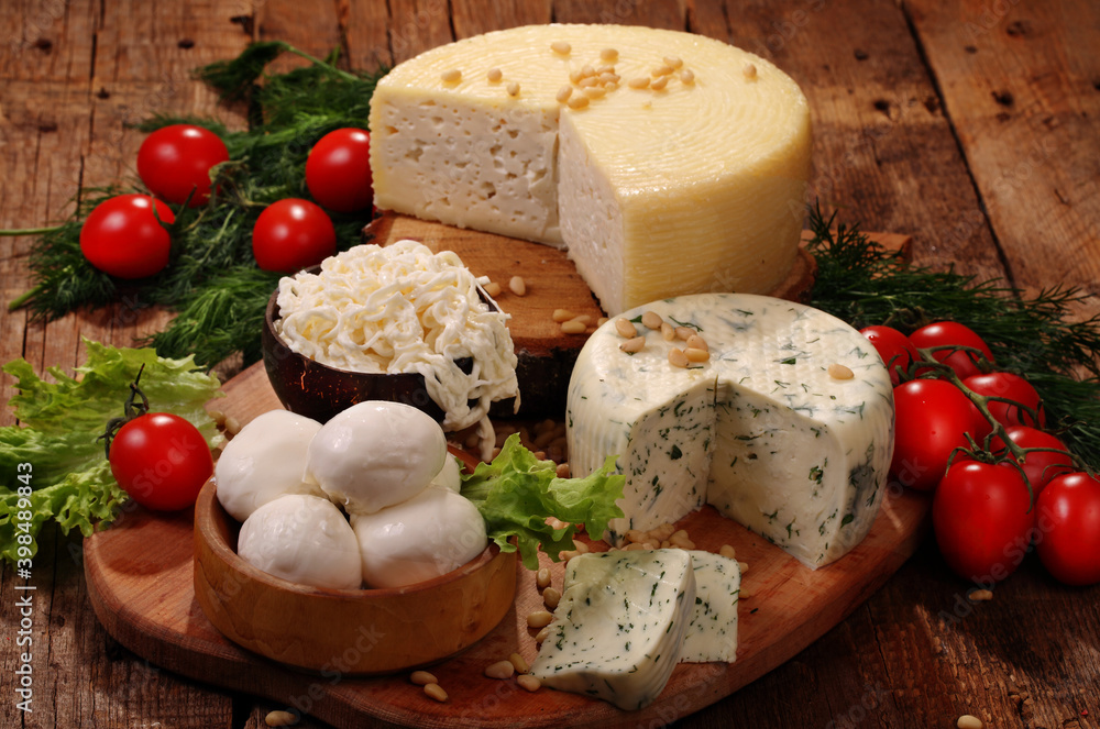 Cheese platter of tomatoes and herbs on a wooden table Cheese platter of tomatoes and herbs on a wooden table