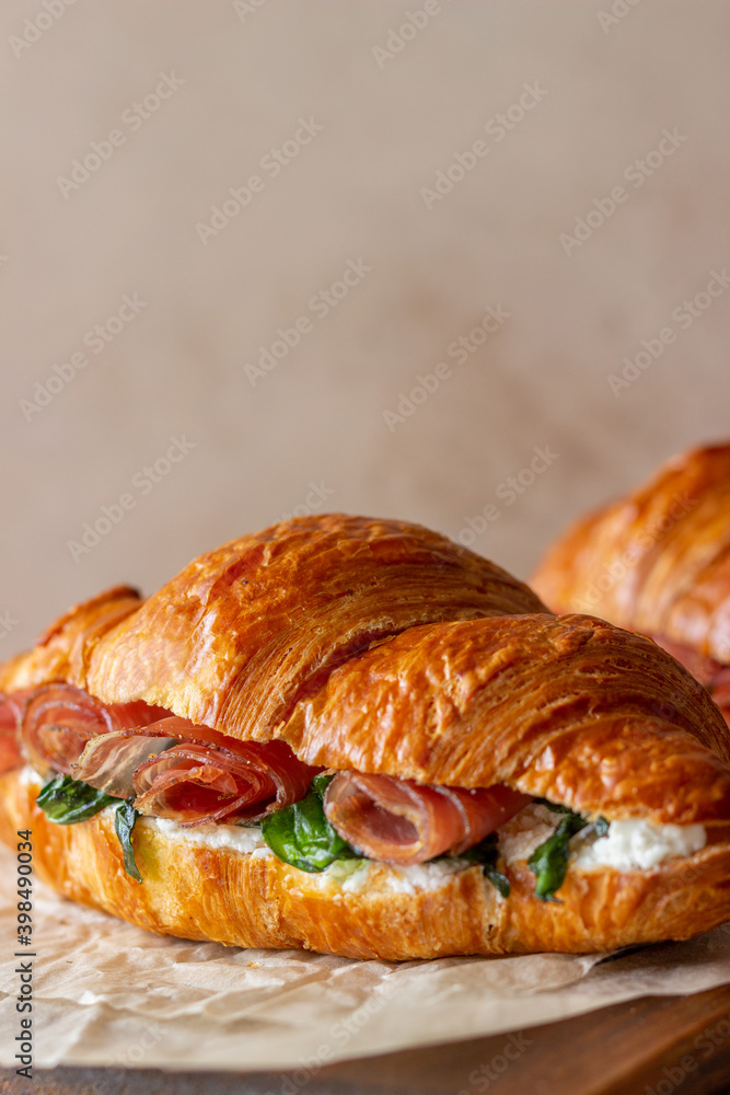 Croissants sandwiches with prosciutto, basil and white cheese. French cuisine. Breakfast. Croissants sandwiches with prosciutto, basil and white cheese. French cuisine. Breakfast.