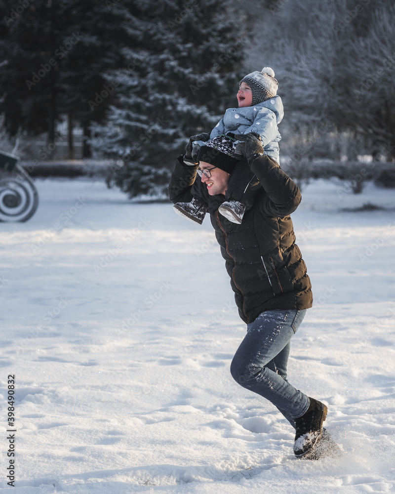 Young father and little boy playing together in winter park