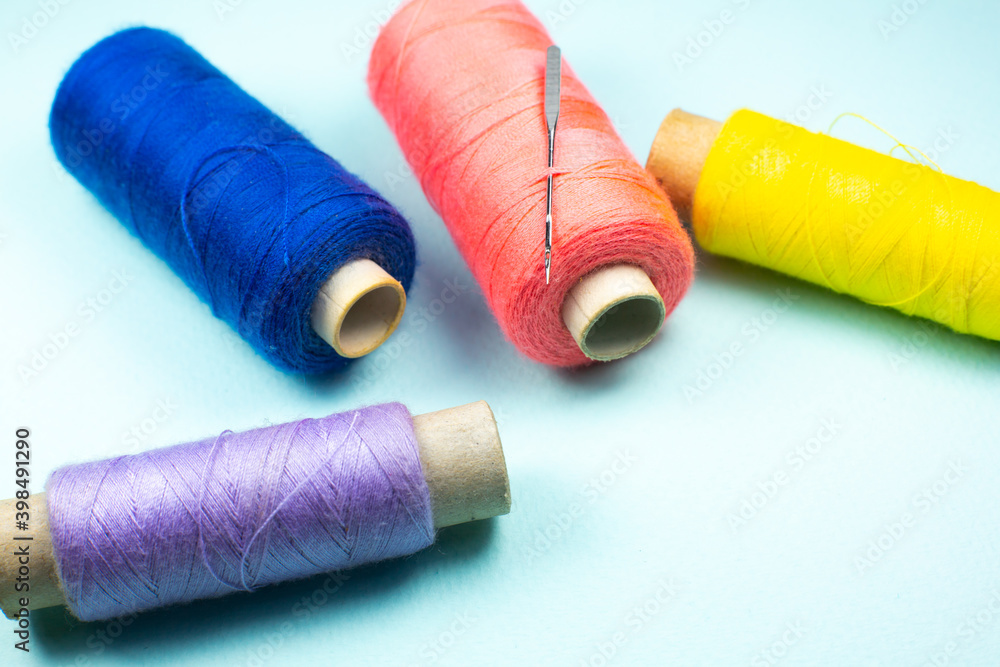Colorful spools of thread with a needle, close up. Colorful spools of thread with a needle, close up.