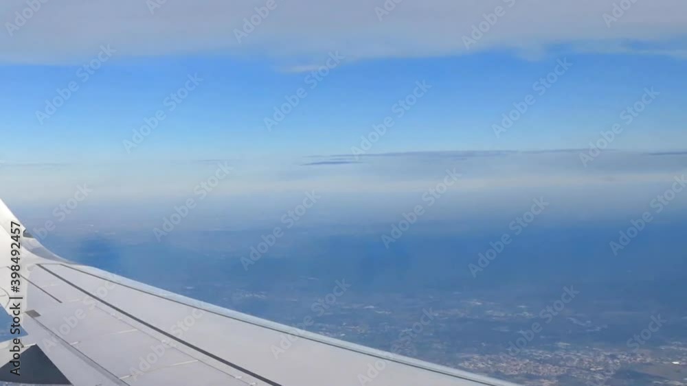 View from the window of an airplane flying above big city. View from the window of an airplane flying above big city.
