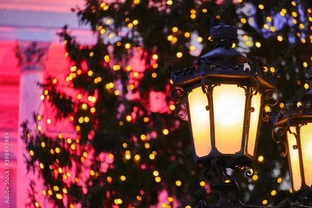 The classic old street lamp. The Christmas tree and Helsinki Cathedral on the blurred background.