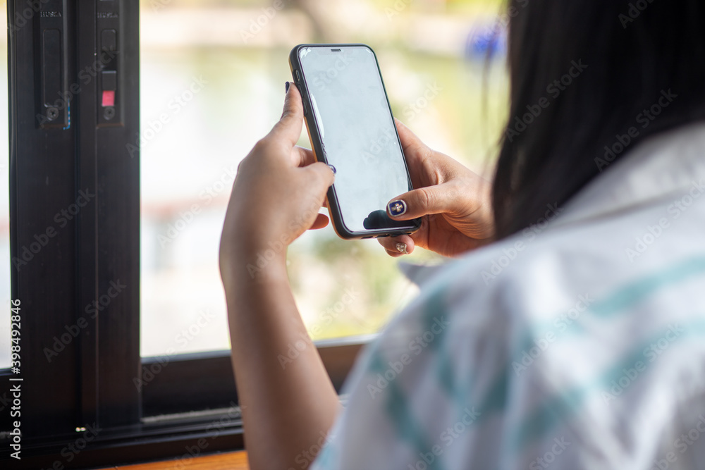 Close up of a woman using a mobile phone in a cafe Close up of a woman using a mobile phone in a cafe