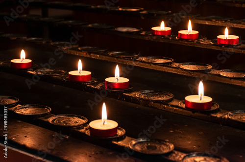 Several red candles on a black votive stand.