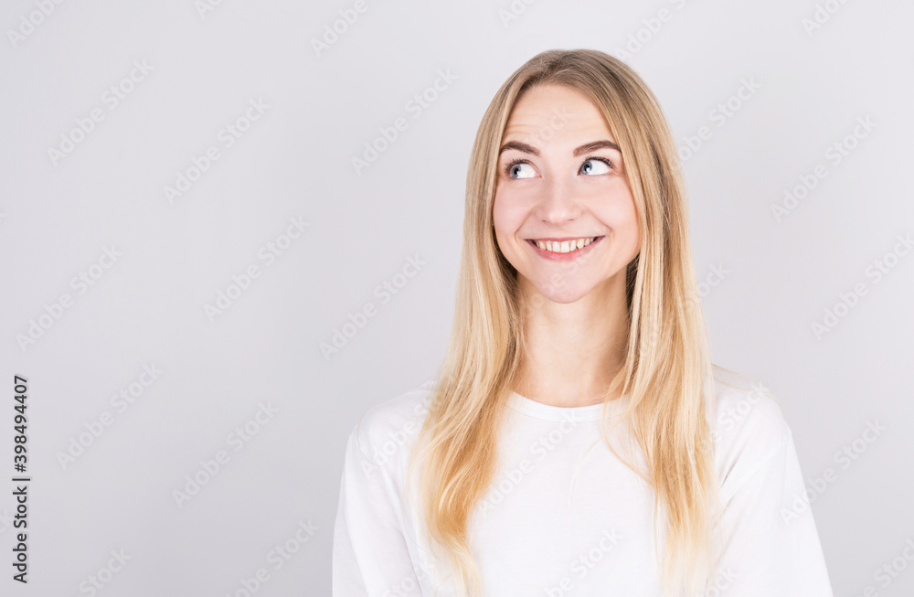 Photo of amazing smiling blonde girl looking up empty space isolated on grey background with copyspace. Photo of amazing smiling blonde girl looking up empty space isolated on grey background with copyspace.