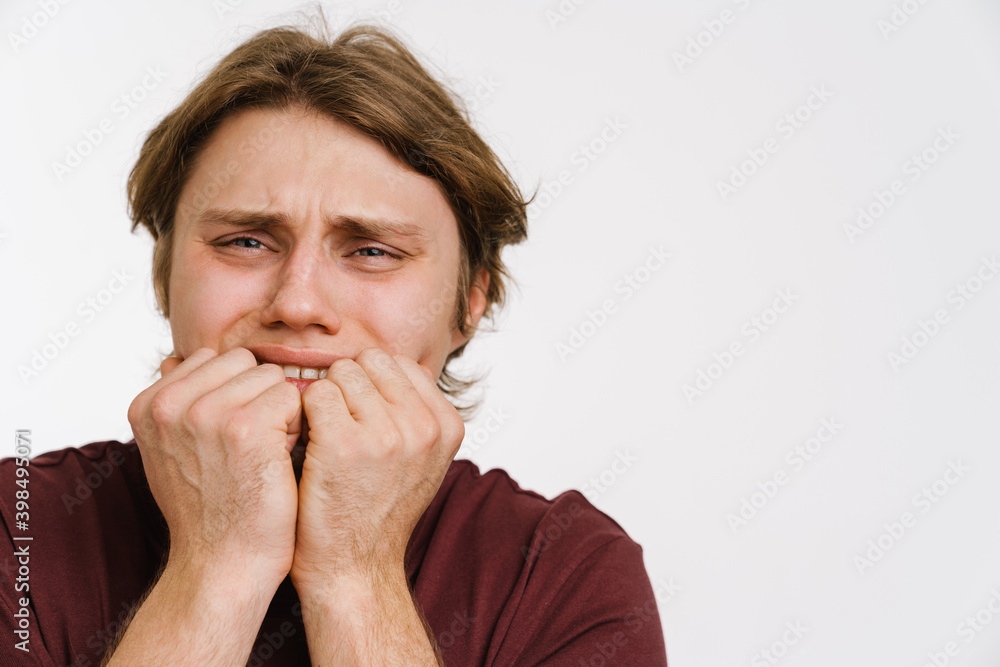 Young scared man covering face with hands isolated Young scared man covering face with hands isolated