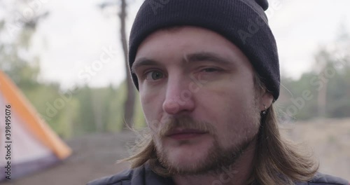 Young tourist man looking at the camera, gives a wink and smiles to the viewer.