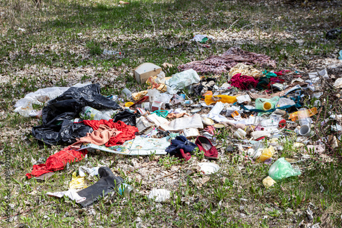 Illegal dumping of household rubbish on spring meadow